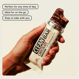 Clean Protein Bar Chocolate Almond XXL Nutrition abierta en la mano como snack proteico práctico para llevar